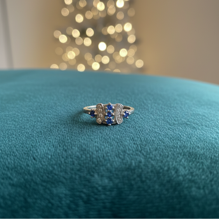Vintage-Inspired Silver Ring with Ornate Blue Gemstone and Diamond Accents.