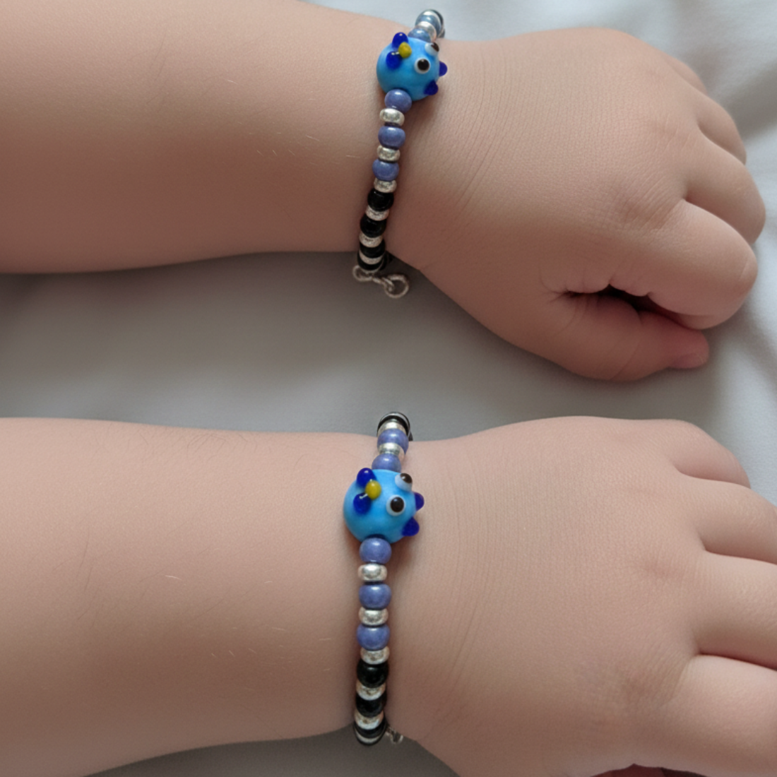 Charming Black and Silver Beaded Bracelet with Whimsical Blue Cartoon Glass Centerpiece.